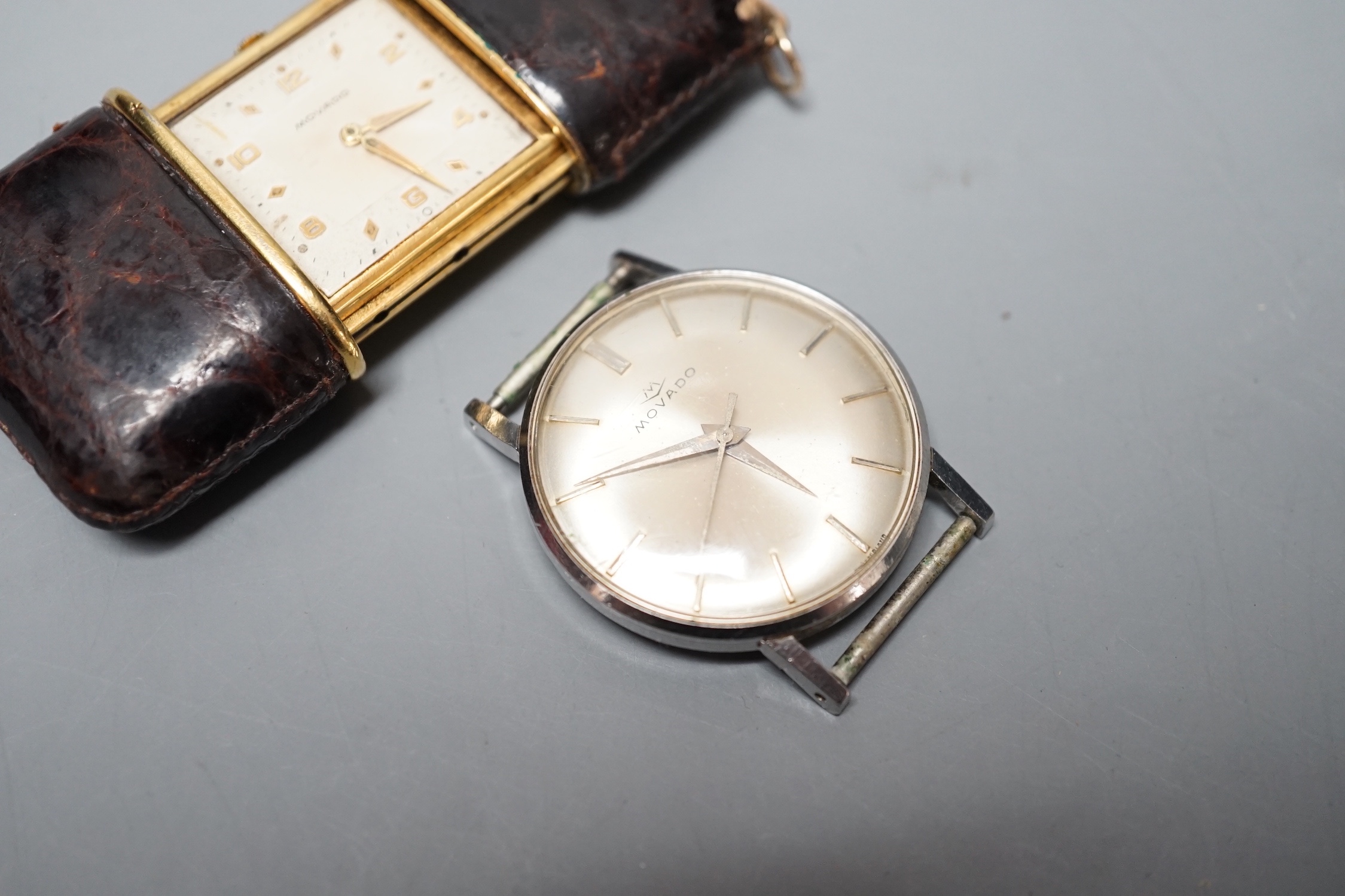 A Movado leather mounted gilt metal travelling timepiece, 49mm and a stainless steel Movado manual wind wrist watch(lacking winding crown).